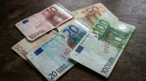 Banconote in euro disposte su un tavolo di legno, alcune marcate come fac-simile o specimen