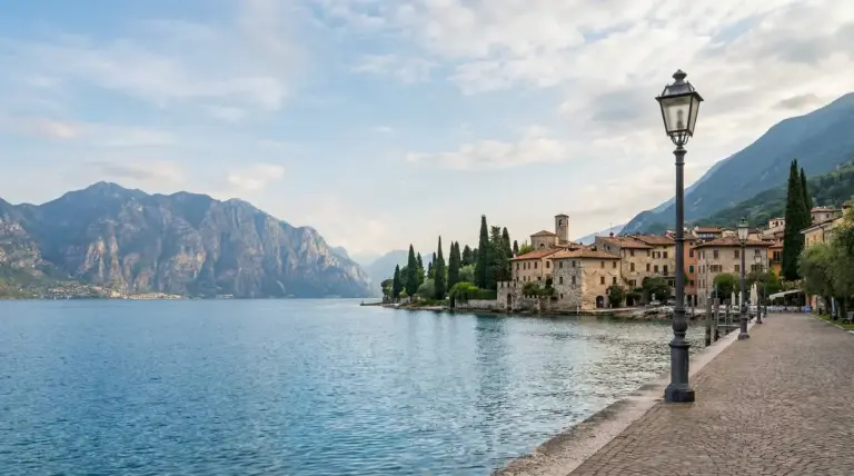 Vista panoramica del Lago di Garda con un borgo storico e montagne sullo sfondo